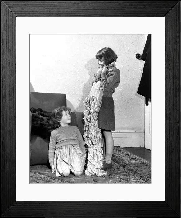 Framed Print : Girl holding up dress to show her sister December 1951
