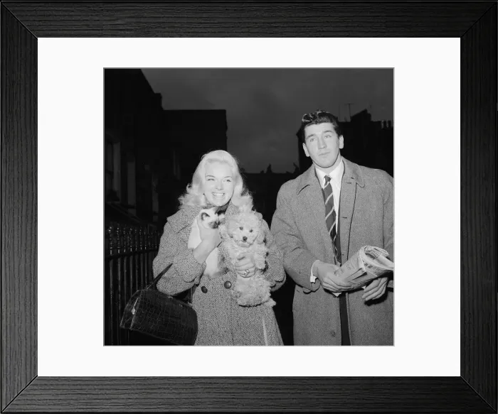 Framed Print : Actress Diana Dors holding her pet dog as she arrives at court on assault charges with