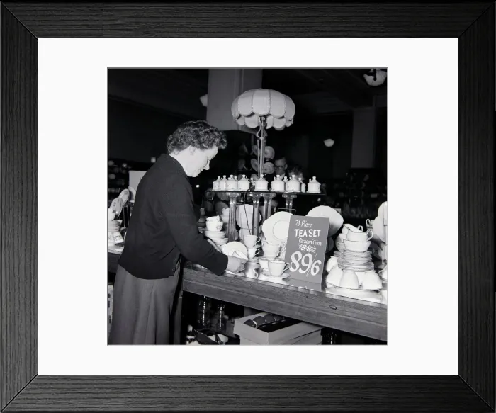 Framed Print : An elderly lady looking for bargains during january sales at Derry