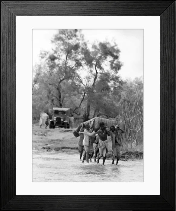Framed Print : Local men of Abyssinia carring heavy objects across a river Circa 1935 People
