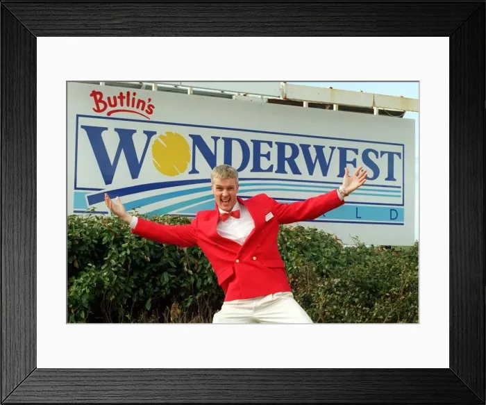 Framed Print : Redcoat Aidan welcomes visitors to Butlins Worderwest World Wonderwest World sign in