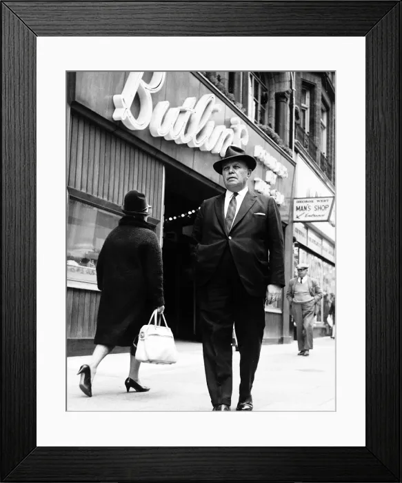 Framed Print : Billy Butlin walking past one of his Butlins shop on the high street. Dbase Framed Print : Billy Butlin walking past one of his Butlins shop on the high street. Dbase