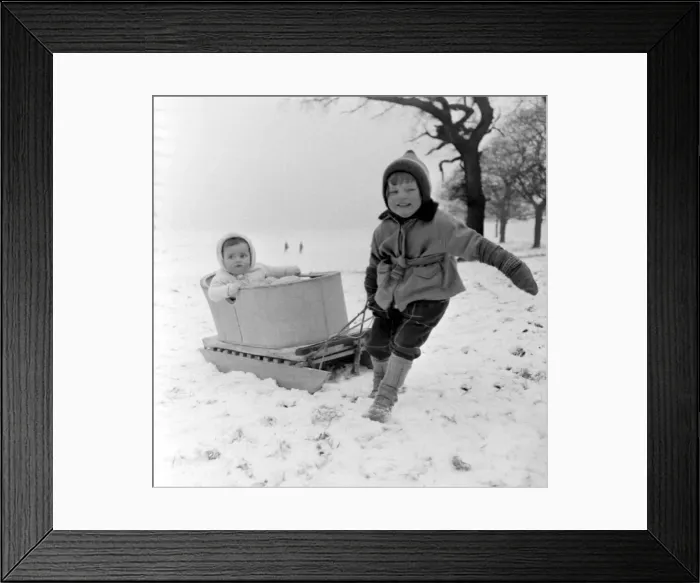 Framed Print : Three year old girl Linda Torkington pulls along her 10 month old baby sister Susan in a Framed Print : Three year old girl Linda Torkington pulls along her 10 month old baby sister Susan in a
