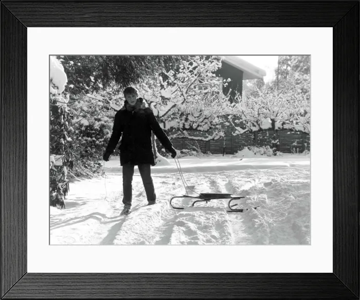 Framed Print : Paperboy Stephen Sales delivers his newspapers using a sledge after heavy snow in England Framed Print : Paperboy Stephen Sales delivers his newspapers using a sledge after heavy snow in England