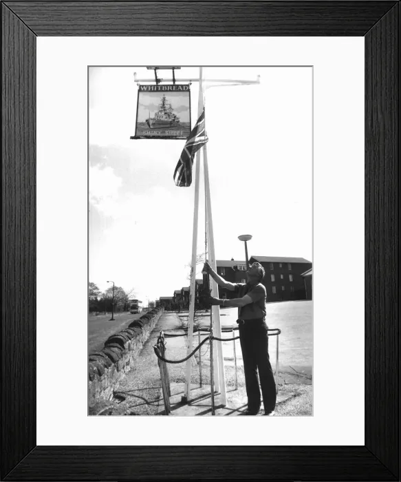 Framed Print : Publican Fred Howe lowers the Union Jack outside his hostel