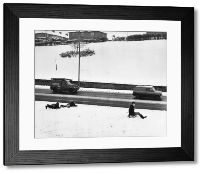 Framed Print : Youngsters sledge down the snow covered bank stopping only feet off the busy Newcastle Framed Print : Youngsters sledge down the snow covered bank stopping only feet off the busy Newcastle