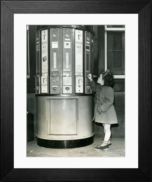 Framed Print : A young girl at a vending machine on Newcastle Central Station in 1954