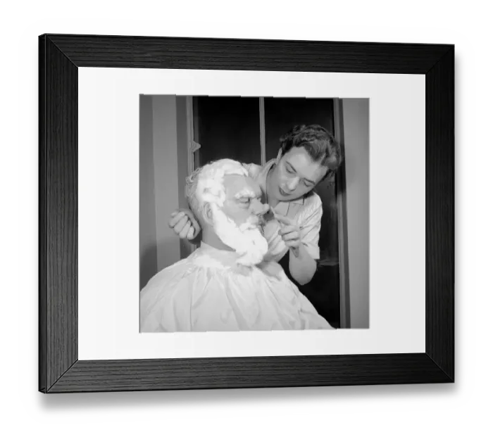 Framed Print : TV Make up artist seen transforming an actor in to Santa Claus for a television drama