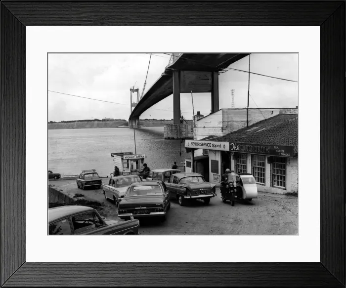 Framed Print : Severn Ferry - Cars queue up for the ferry with the recently completed bridge towering Framed Print : Severn Ferry - Cars queue up for the ferry with the recently completed bridge towering