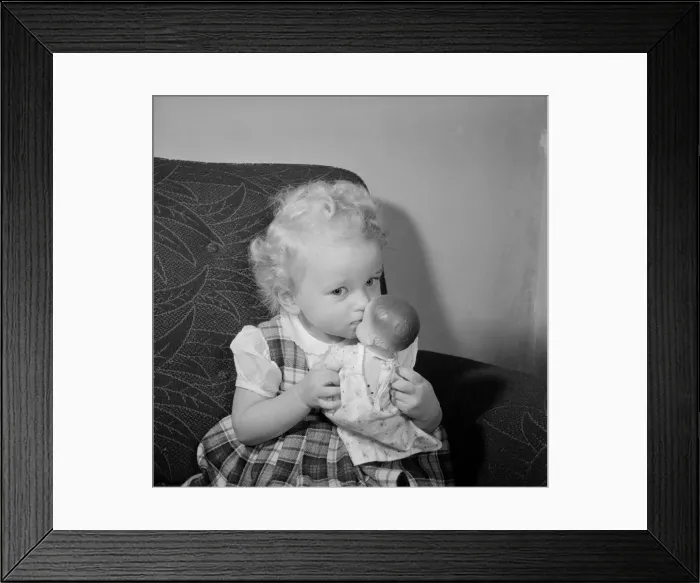 Framed Print : A small girl plays with her doll Circa 1957 Framed Print : A small girl plays with her doll Circa 1957