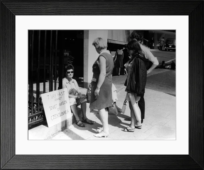 Framed Print : Pacifist campaigner Pat Arrowsmith asitting on the kerb outside the gates of Kensington