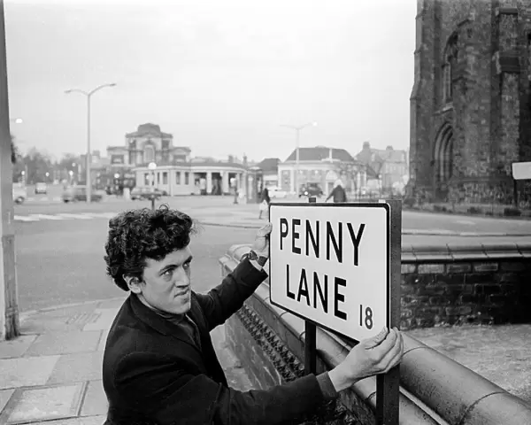 Bill Carrington holds Penny Lane Street Sign in Liverpool made famous by The Beatles