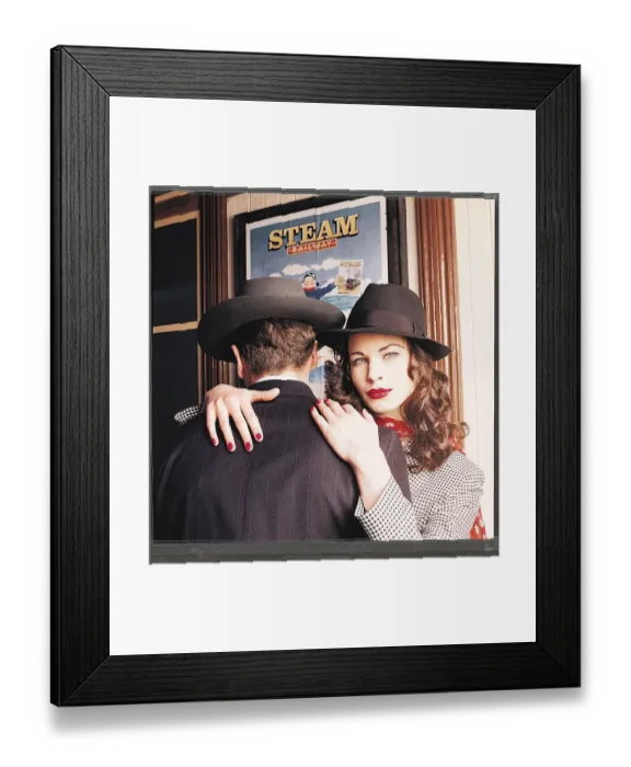 Framed Print : 1940s dress fashion - Female model wearing black hat with her arms around male model