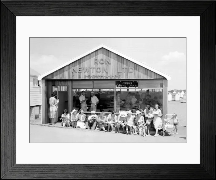 Framed Print : Holidaymakers enjoy the sunshine as they sit outside a betting shop in the form of a Framed Print : Holidaymakers enjoy the sunshine as they sit outside a betting shop in the form of a