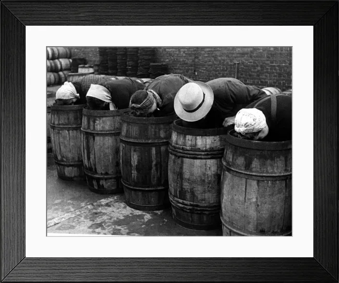 Framed Print : Hat fashions seen at Yarmouth as fisher girls bend over barrels whilst packing herring