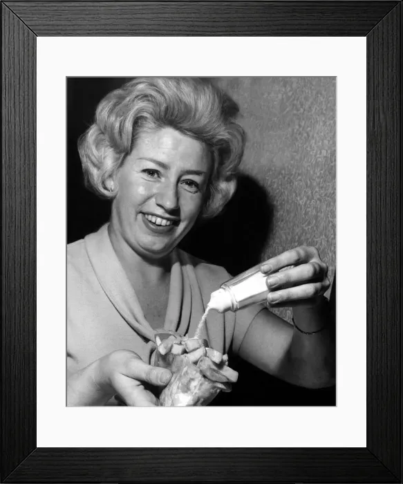 Framed Print : Woman adding salt to a bag of chips - October 1961 Framed Print : Woman adding salt to a bag of chips - October 1961