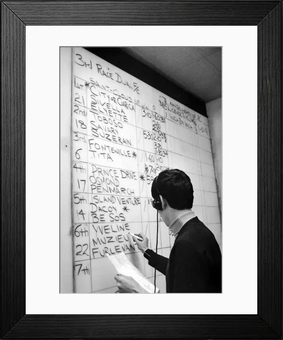 Framed Print : The results of the racing at Saint Cloud in Paris are marked on the board at Ladbrokes