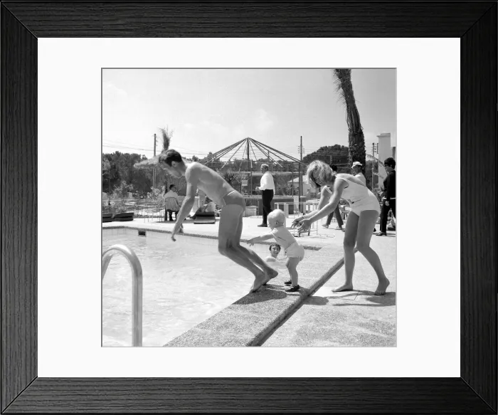 Framed Print : Two year old Gregory Curtis with his mother Jill on holiday in Majorca pushing his dad Framed Print : Two year old Gregory Curtis with his mother Jill on holiday in Majorca pushing his dad
