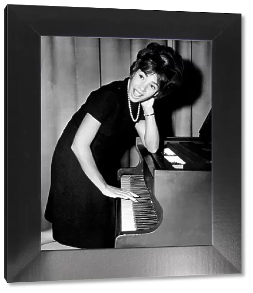 Shirley Bassey tries her hand at the piano during a press conference in the Cocktail
