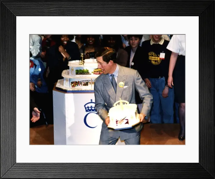 Framed Print : HRH Prince Charles about to throw a birthday cake to a crowd of onlookers during his Framed Print : HRH Prince Charles about to throw a birthday cake to a crowd of onlookers during his
