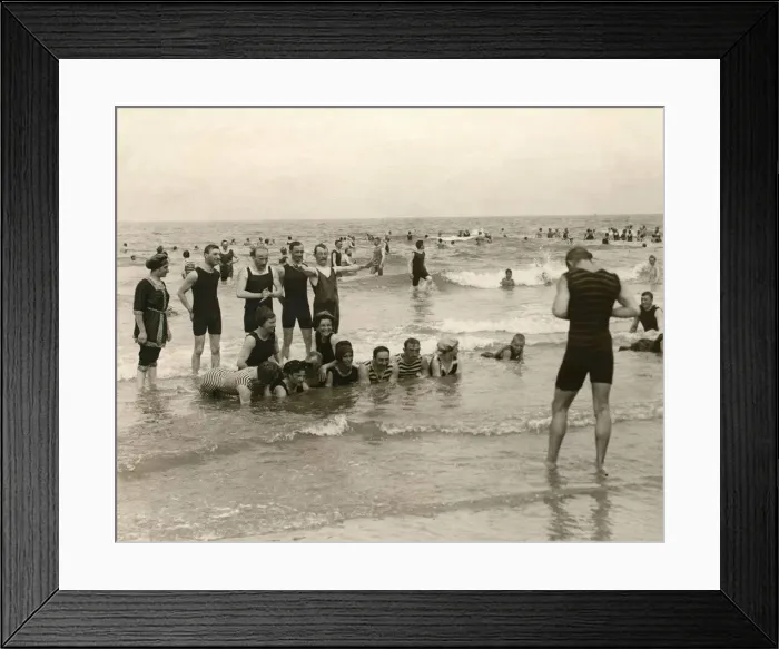Framed Print : Holidaymaker taking a photograph of his friends bathing in the sea at Norderney