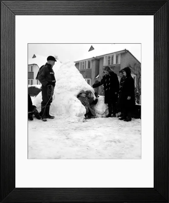 Framed Print : Weather - Snow - Cold Children building a snow house  /  igloo in the street - waving