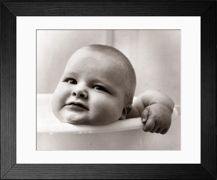 Framed Print : Baby in a bath tub, looking over the side. December 1963 Framed Print : Baby in a bath tub, looking over the side. December 1963