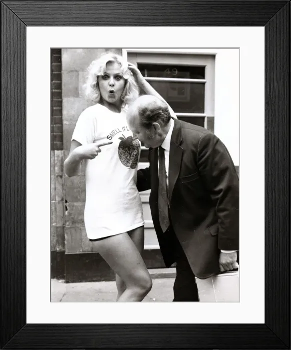 Framed Print : Marie Louis wearing a T Shirt with Strawberry Print as a man moves in to have a smell Framed Print : Marie Louis wearing a T Shirt with Strawberry Print as a man moves in to have a smell