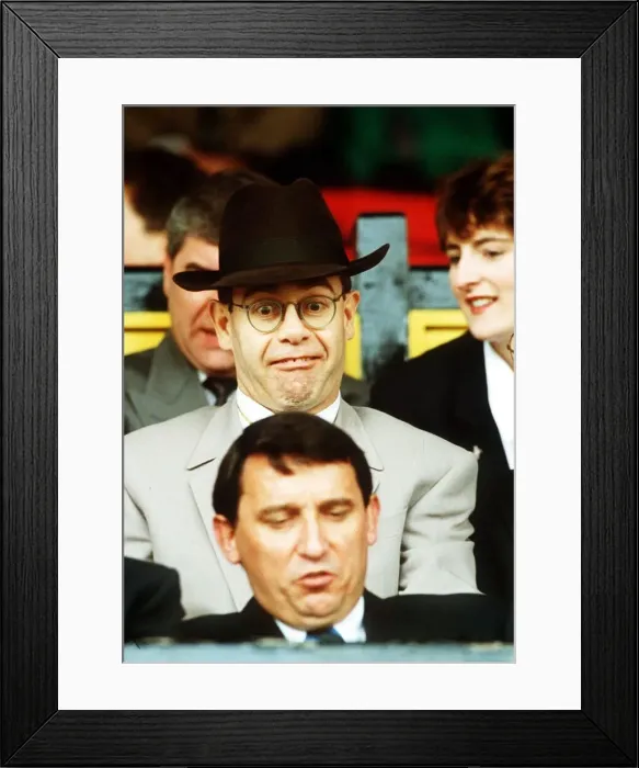 Framed Print : Elton John Singer & Chairman of Watford FC pulls a funny face at Manager Graham Taylor