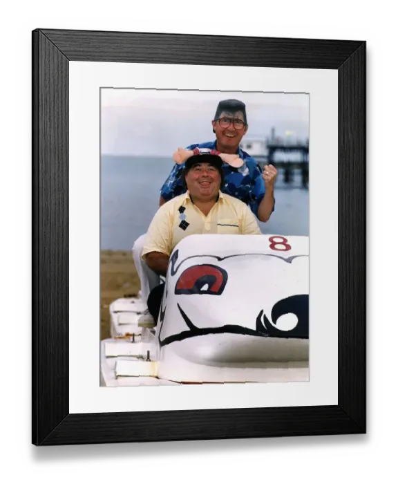 Framed Print : Little & Large Comedy Duo Sitting in toy car on beach wearing funny hat and wig Dbase