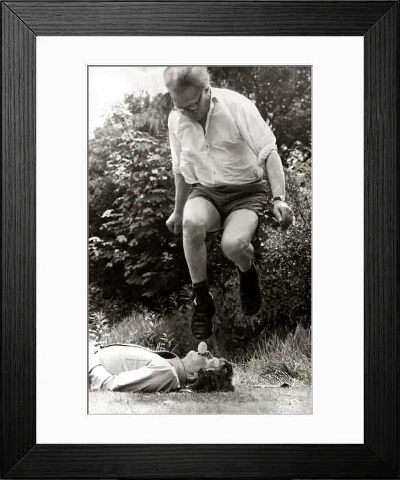 Framed Print : A man leaping over mans face holding an egg in mouth January 1974 Framed Print : A man leaping over mans face holding an egg in mouth January 1974