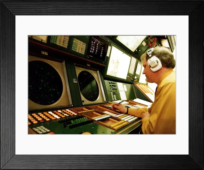 Framed Print : Air Traffic control man wearing earphones headphones at instruments desk airport control Framed Print : Air Traffic control man wearing earphones headphones at instruments desk airport control