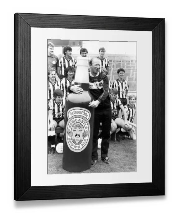 Framed Print : Newcastle United manager Jack Charlton clowning around with a giant Newcastle Brown Ale