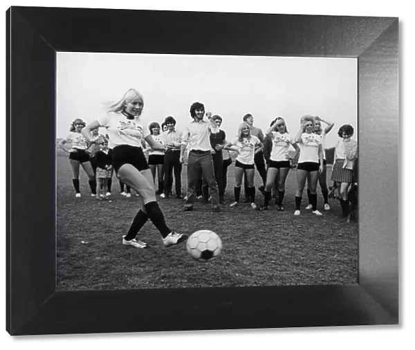 Miss Eva Haralsted takes a penalty shot under the watchful eye of fiancee George Best
