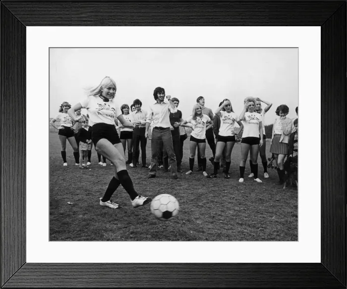 Framed Print : Miss Eva Haralsted takes a penalty shot under the watchful eye of fiancee George Best Framed Print : Miss Eva Haralsted takes a penalty shot under the watchful eye of fiancee George Best