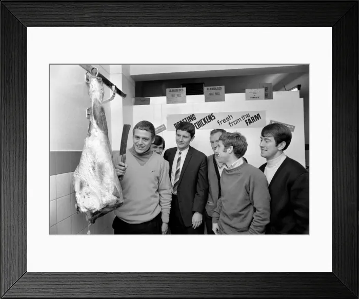 Framed Print : The big carve up - Gordon West about to chop through a large leg of beef watched by his Framed Print : The big carve up - Gordon West about to chop through a large leg of beef watched by his