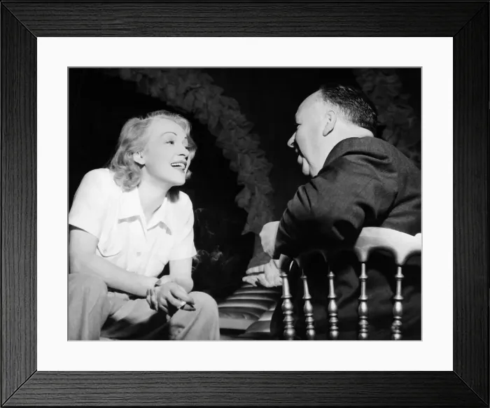 Framed Print : Marlene Deitrich talks to Alfred Hitchcock film director 1949 Framed Print : Marlene Deitrich talks to Alfred Hitchcock film director 1949