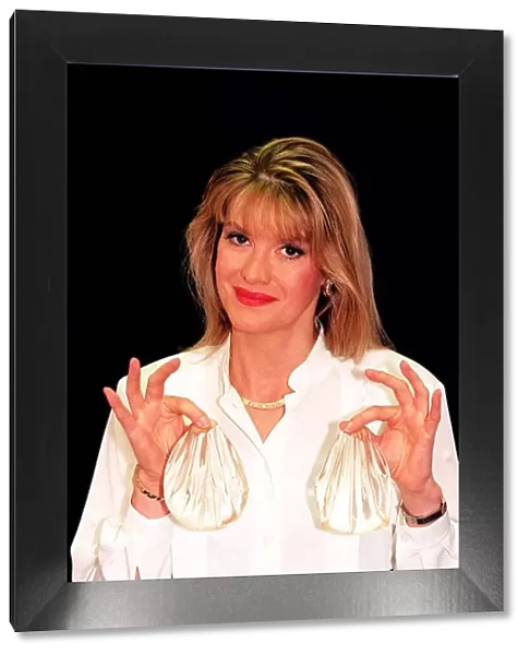 Cindy Jackson who has had major plastic surgery holding spherical silcone bags