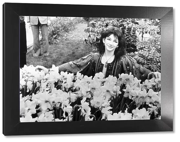 Pop singer Kate Bush poses in a garden full of daffodils, Tuesday 17th April 1979