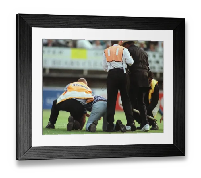 Framed Print : John Holder umpire is helped by steward after he was knocked to the ground by a fan
