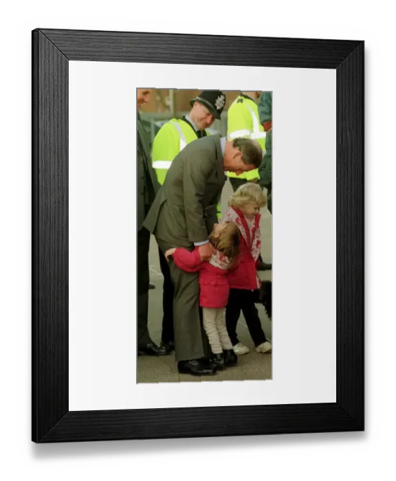 Framed Print : Prince Charles gets an unexpected hug from four year old Sarah Norris during a school