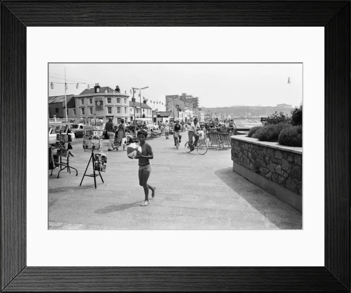 Framed Print : A young boy holding his beach at the seafront in St Helier on the Channel Island of Framed Print : A young boy holding his beach at the seafront in St Helier on the Channel Island of