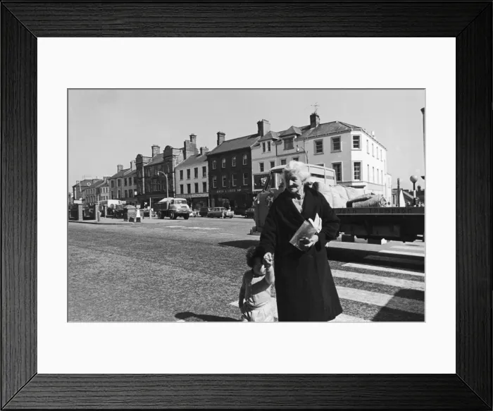 Framed Print : A grandmother and her grandaughter crossing the main road in Lurgan after paying a visit Framed Print : A grandmother and her grandaughter crossing the main road in Lurgan after paying a visit