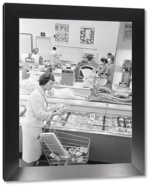 Shopper browsing the butchers counter at a newly opened self service food store in North