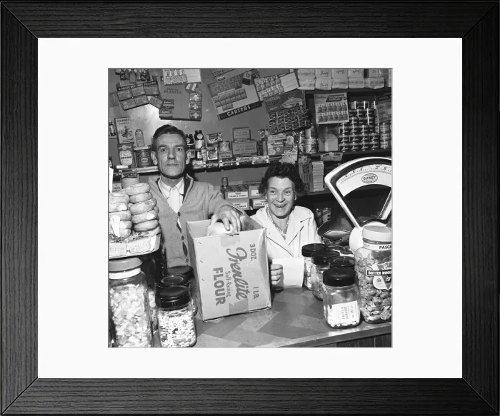 Framed Print : Local grocer and his wife seen here serving a customer. 14th November 1955 Framed Print : Local grocer and his wife seen here serving a customer. 14th November 1955