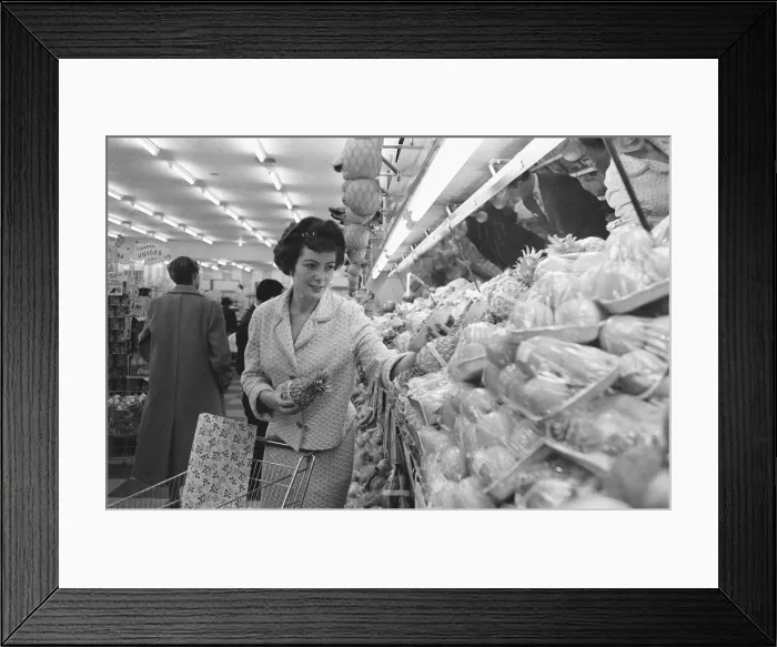 Framed Print : Shoppers browsing the fruit counter at a newly opened self service food store in North Framed Print : Shoppers browsing the fruit counter at a newly opened self service food store in North