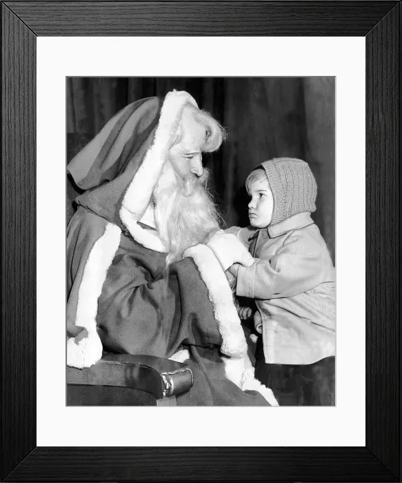 Framed Print : Brian Mace, aged two, has a chat with Santa Claus. Brian is visiting his grandmother in Framed Print : Brian Mace, aged two, has a chat with Santa Claus. Brian is visiting his grandmother in
