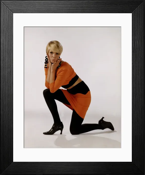 Framed Print : Model in orange and black top and mini skirt, black shoes