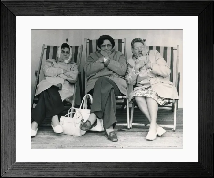 Framed Print : Three women Holidaymakers are all wrapped up in coats and scarves as they fight off Framed Print : Three women Holidaymakers are all wrapped up in coats and scarves as they fight off