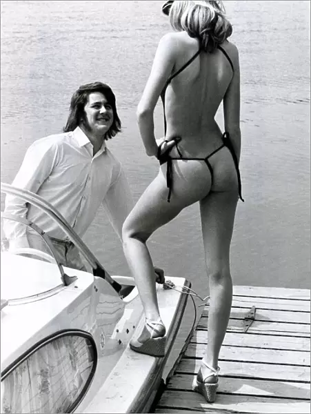 A man on his boat looks admiringly at model Carol Dwyer